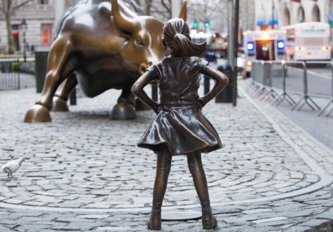 Photograph of the Fearless Girl statue by Kristen Visbal across Arturo Di Modicas Charging Bull statue in Manhattans financial district.